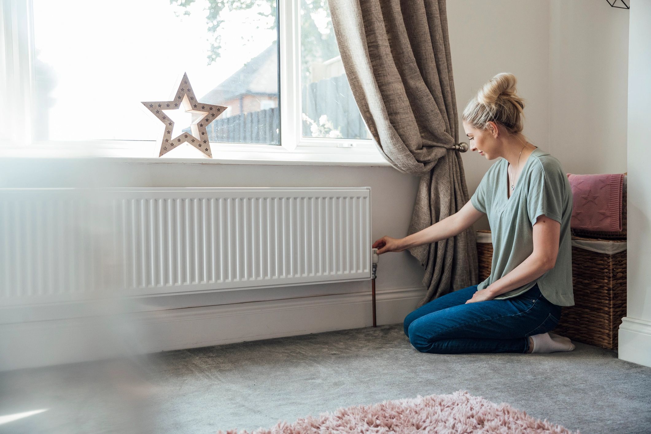 Homeowner adjusting a thermostat for comfortable indoor heating